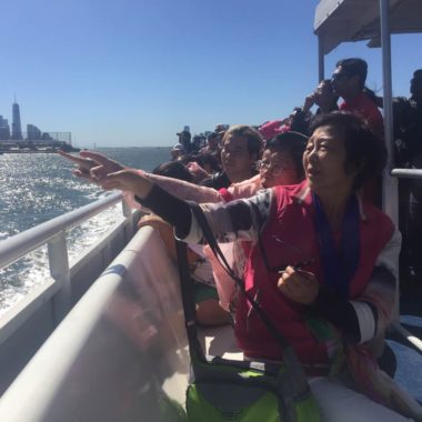 Chinese tourists take a ferry circling around Statue of Liberty in New York in September. The number of Chinese tourists in the United States has more than doubled in the last year. [Photo By DAVID PAN / NYU Journalism School]